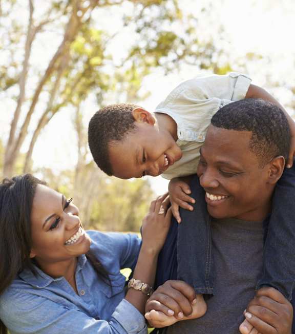 A family of three enjoying a sunny day outdoors.