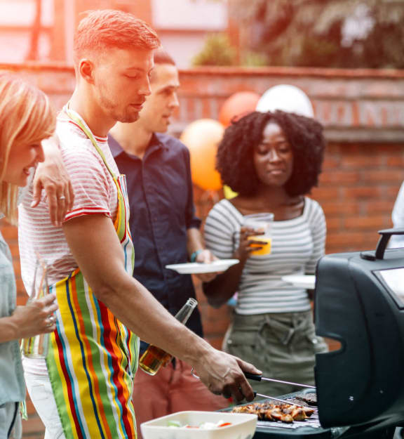 a group of people standing around a barbecue grill at Savan Pointe Townhomes East and West, Savannah Georgia