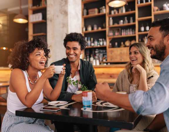 a group of people sitting around a table in a restaurant