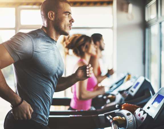 a man running on a treadmill in a gym