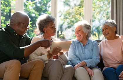 Four people sitting on a couch, sharing a moment together.