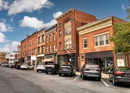 Cars parked on the side of a street in front of a row of buildings.