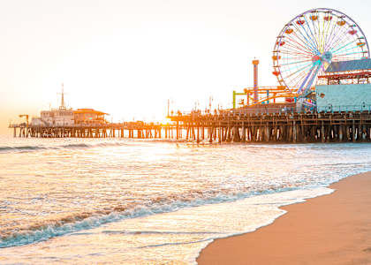 A pier with a Ferris wheel and a building on it.