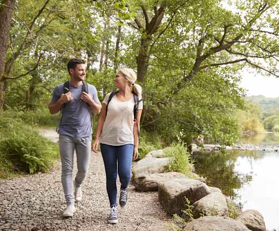 a man and a woman walking by a river at Edgebrook Residences, Merrimack, NH 03054