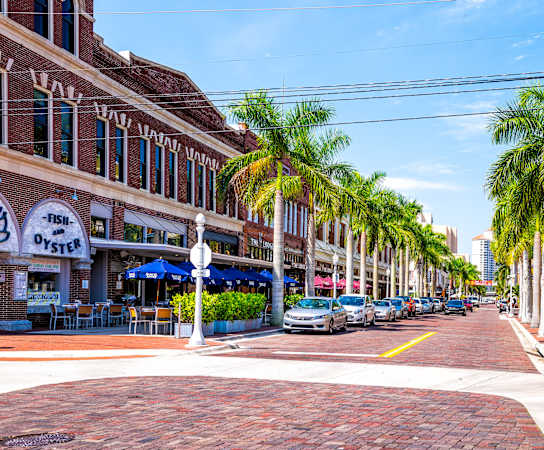 a street in charleston with cars parked on the side of the road and palm trees at Bay Harbor, Fort Myers, FL, 33919