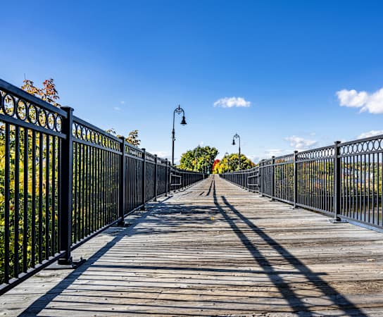 a bridge with a fence on both sides and a blue sky in the background at Residences at Manchester Place, Manchester