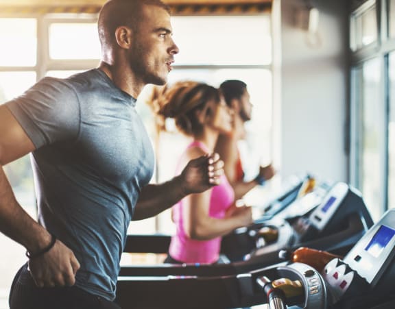 a man running on a treadmill in a gym