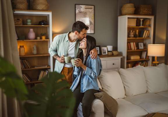 A man and woman are sitting on a couch in a cozy living room.