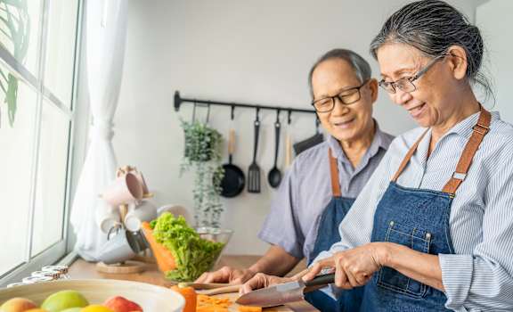 an older couple is cooking in the kitchen at Emblem Alpharetta, Alpharetta, GA