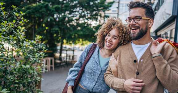 A man and a woman are walking together on a sidewalk.