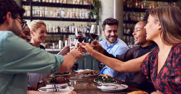 people making a toast at a restaurant table