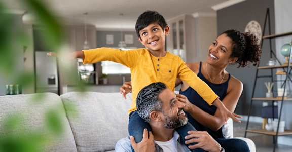 A family of three is having fun in their living room.