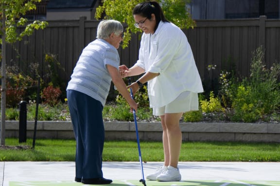 a woman is helping an older woman with a cane