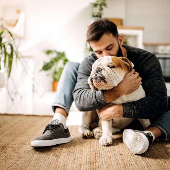 a man sitting on the floor with his dog at Radbourne Lake Apartments, Charlotte, 28269
