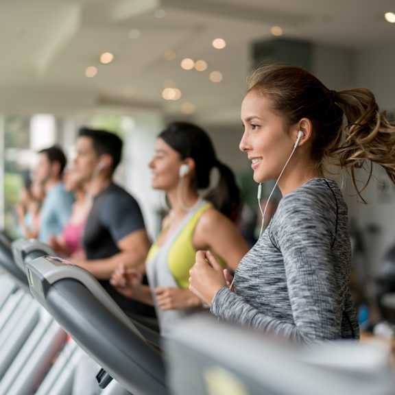 A group of people are exercising on treadmills in a gym.