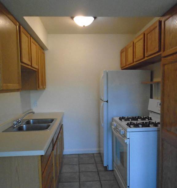 an empty kitchen with boxes on the counter and a stove
