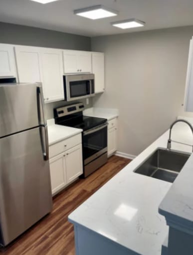 a kitchen with stainless steel appliances and white cabinets