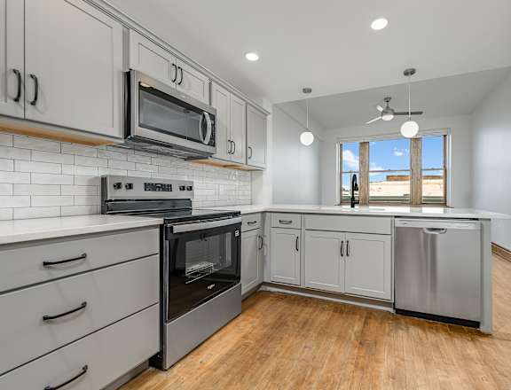 A kitchen with a stainless steel oven and microwave.