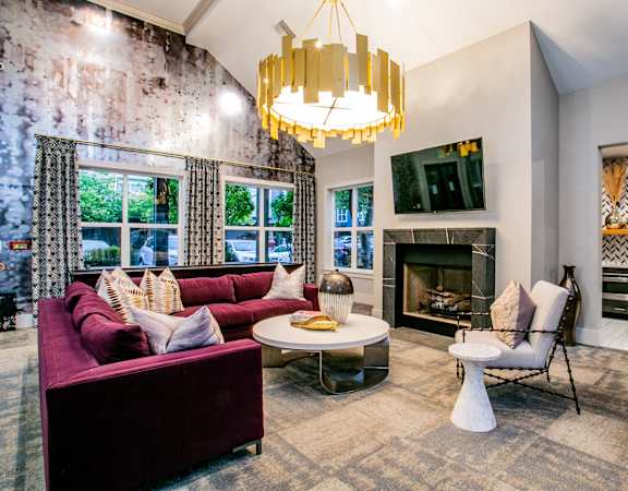 a living room with couches and a fireplace and a chandelier