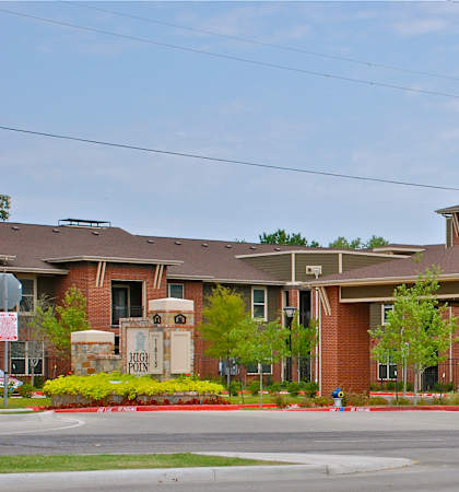 A large brick building with a parking lot in front.