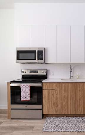 A kitchen with a refrigerator, oven, and microwave.at Art Of Newark, Newark