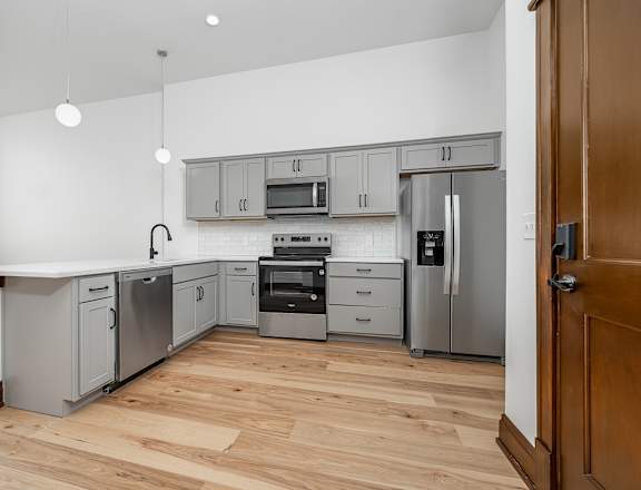 A kitchen with wooden floors and stainless steel appliances.