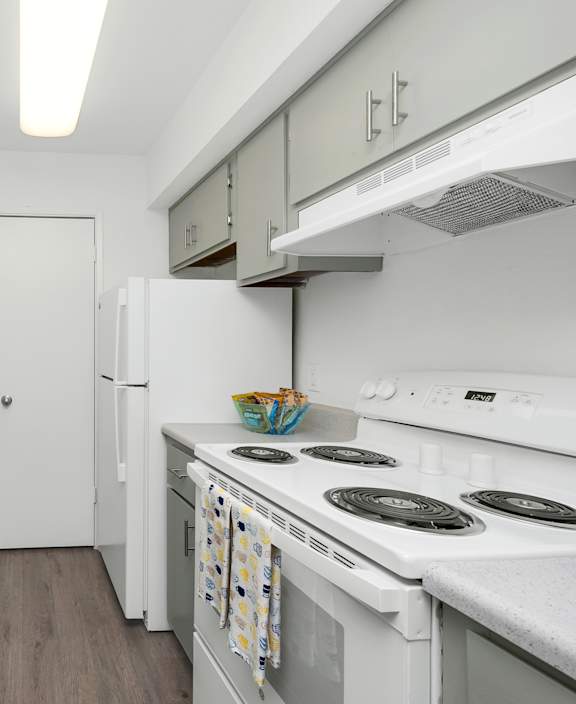 A kitchen with white appliances and a white door.