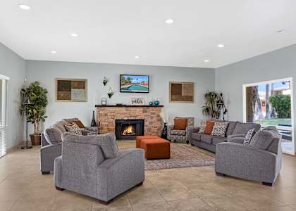 A living room with a fireplace and grey couches.