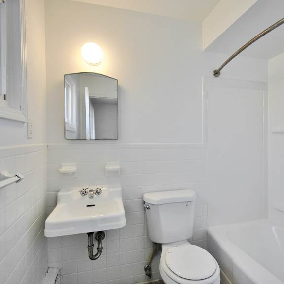 A white bathroom with a toilet, sink, and bathtub.