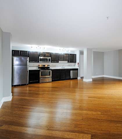 A spacious kitchen with wooden floors and modern appliances.