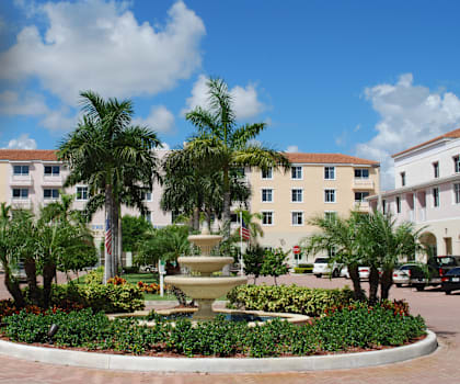 a fountain in the middle of a courtyard with buildings in the background