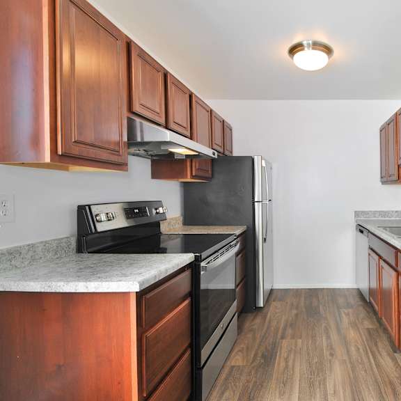 Apartment kitchen with wood cabinets at Huntington Club Apartments in Warren, MI