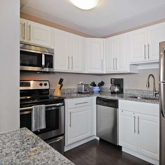 Kitchen with granite countertops and stainless steel appliances at Bancroft Luxury Apartments in Saginaw, MI