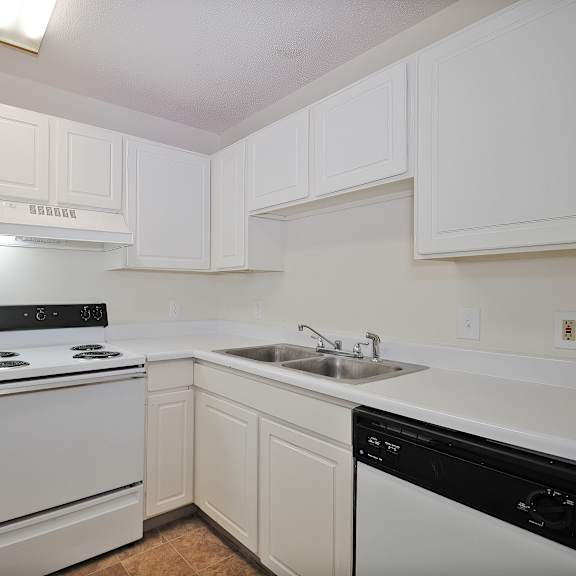 Apartment kitchen with white cabinets and a dishwasher at Hunters Ridge in Kalamazoo, MI
