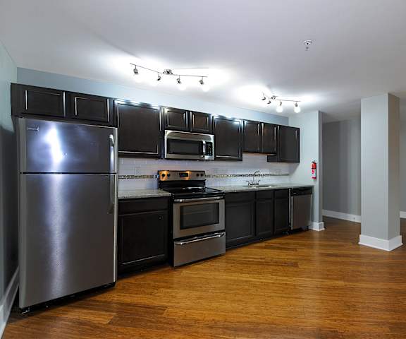 A kitchen with a refrigerator, oven, and microwave.