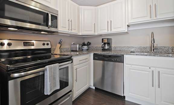 Kitchen with granite countertops and stainless steel appliances at Bancroft Luxury Apartments in Saginaw, MI