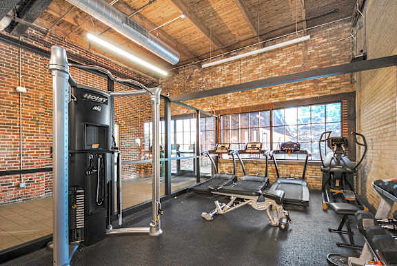 Fitness studio with treadmills, bikes, and weights at Off Broadway Apartments in Grand Rapids