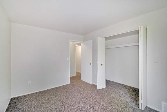 Carpeted bedroom with a large closet at Garfield Commons in Clinton Township, MI