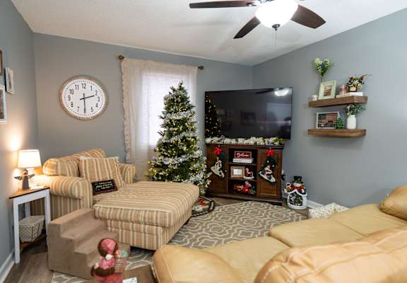 Living room with chair, couch, TV, and Christmas decor.