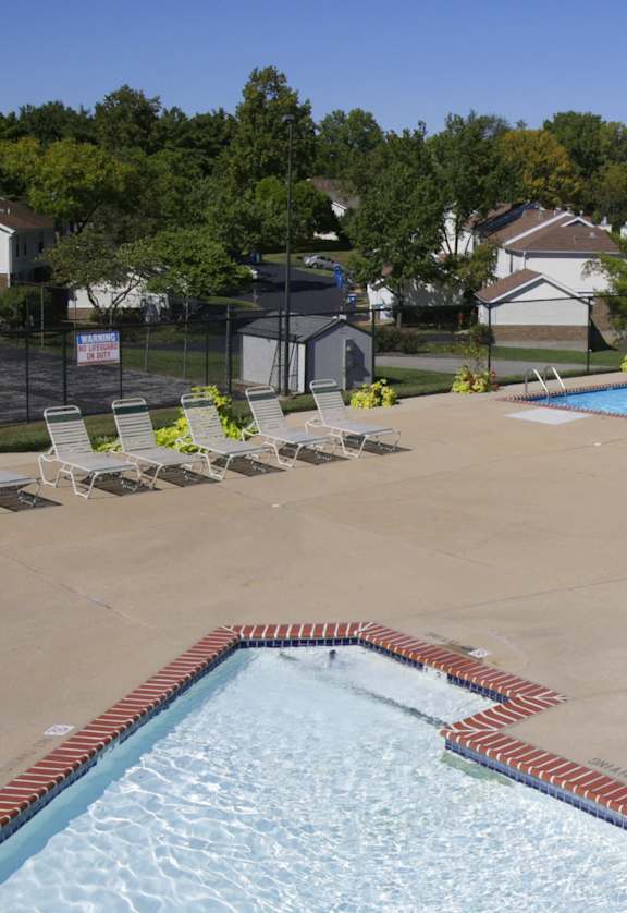 an aerial view of a swimming pool with chairs around it and a resort style pool