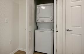 A white dishwasher is in a narrow hallway.