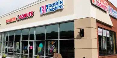 A Dunkin' Donuts storefront with a large window and a sign above it.