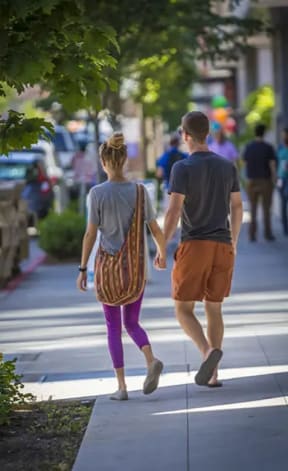 a man and a woman holding hands while crossing a street
