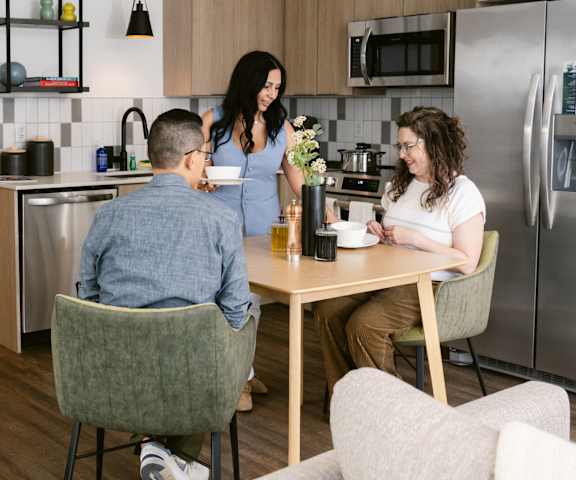 Three people are sitting at a table in a kitchen at Anthem House, Huntsville, 35806