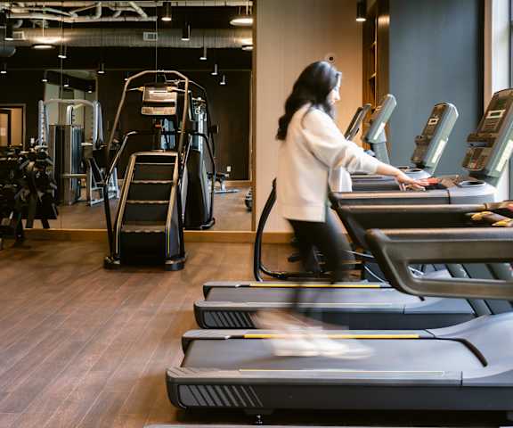A woman is running on a treadmill in a gym at Anthem House, Alabama, 35806