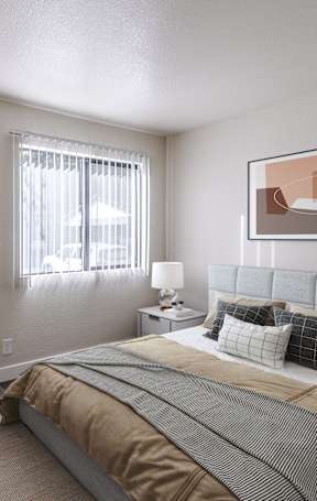 A bedroom with a bed, chair, and two framed artworks on the wall.