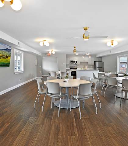 A dining room with a table surrounded by chairs.