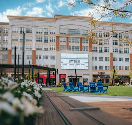 a large white building with blue chairs in front of it