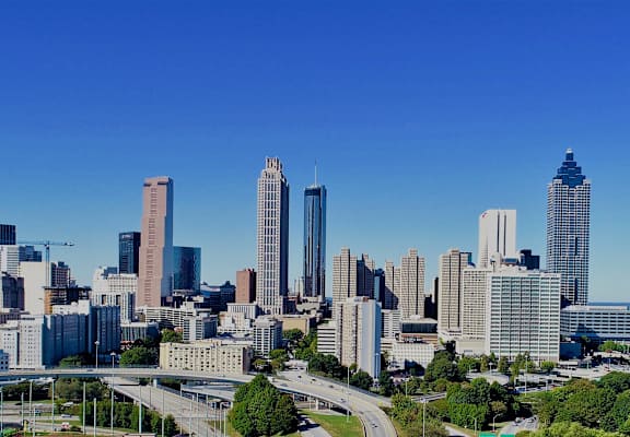 A cityscape with tall buildings and a clear blue sky.