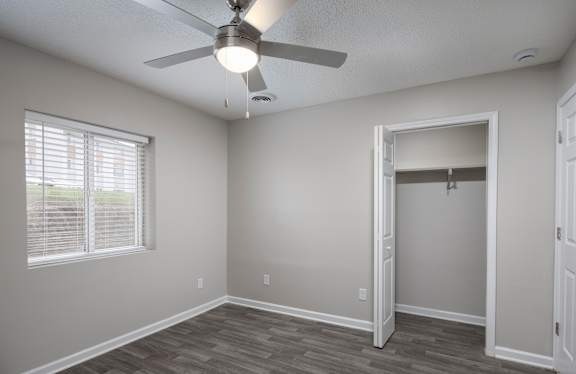 A room with a ceiling fan and a doorway leading to another room.